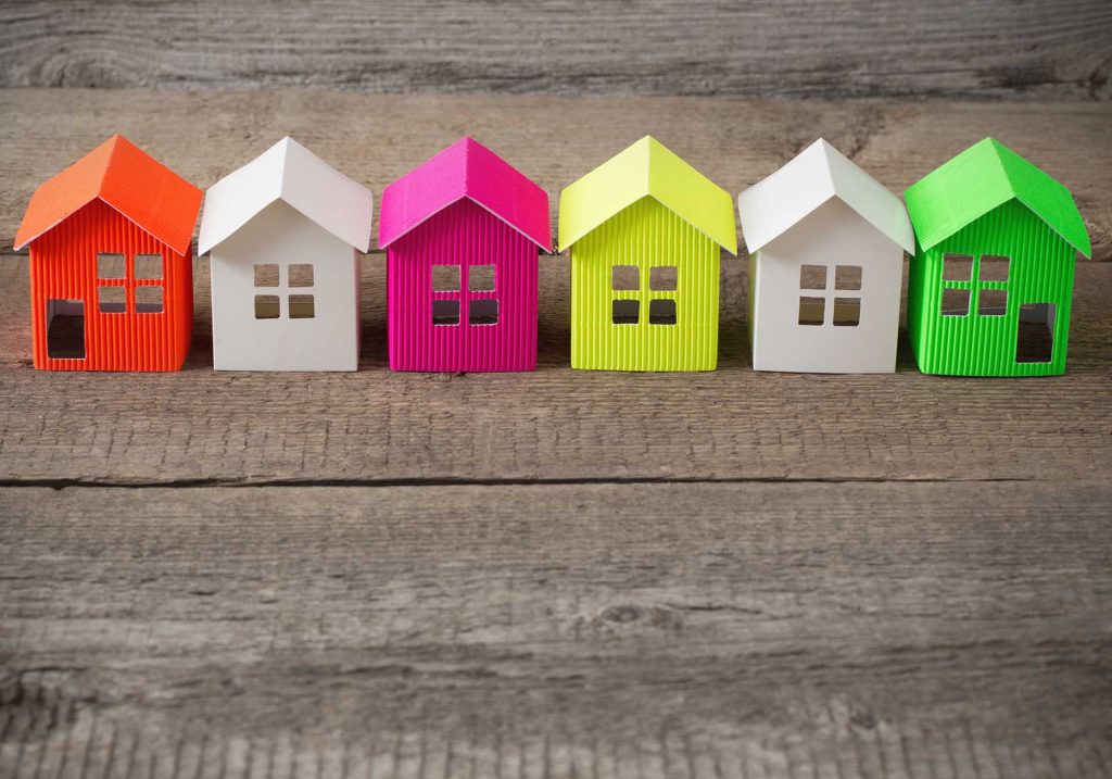 Kleine Häuser aus Papier stehen für die Auswahl von Immobilien beim Verkauf